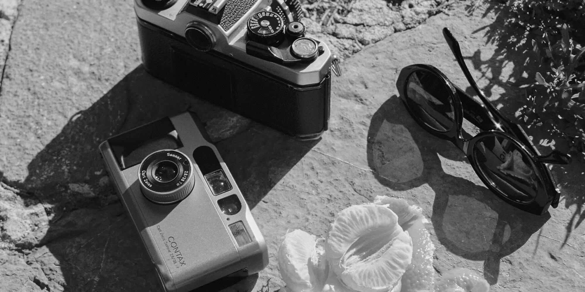 a camera and sunglasses on a rock