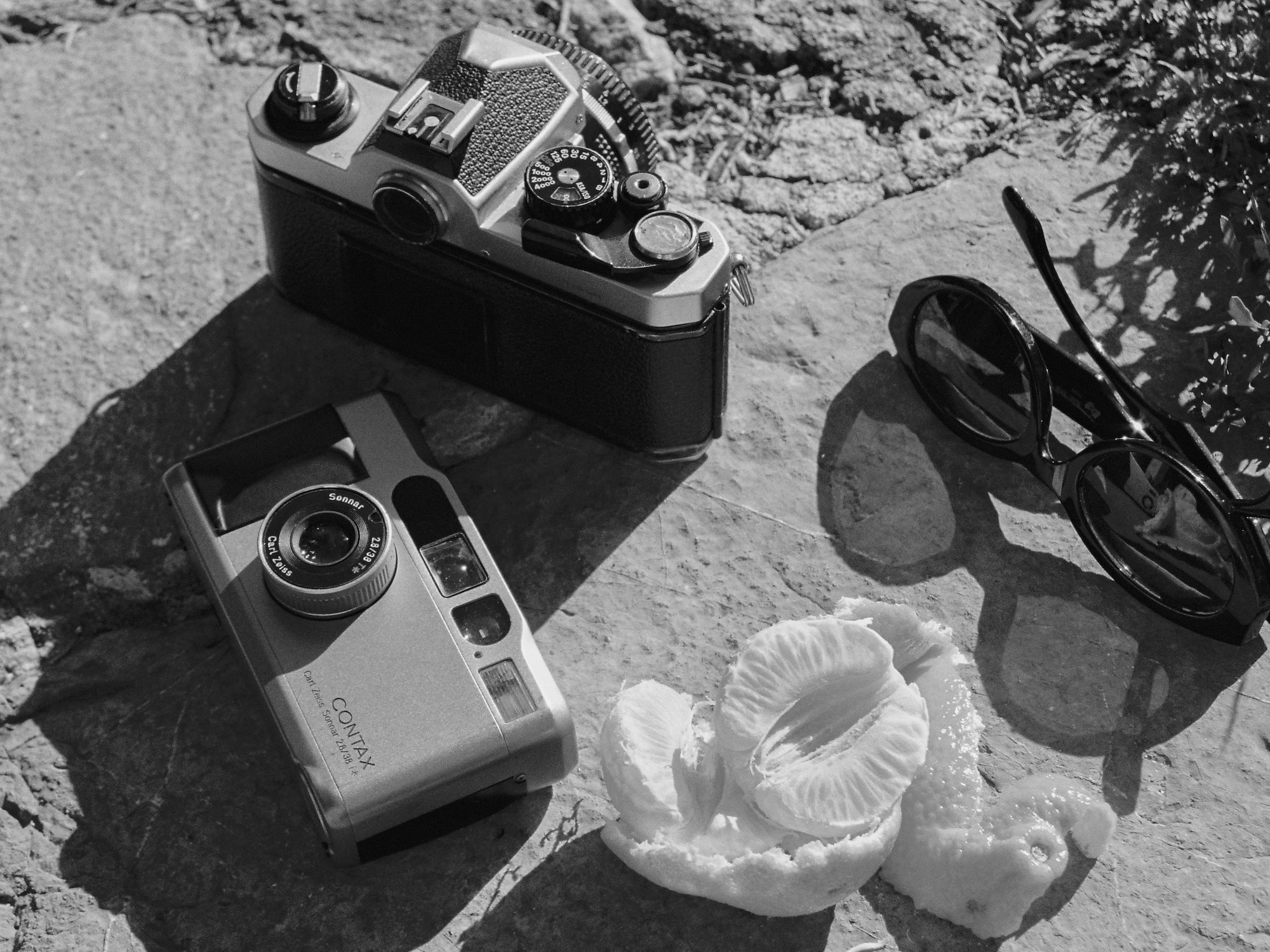 a camera and sunglasses on a rock