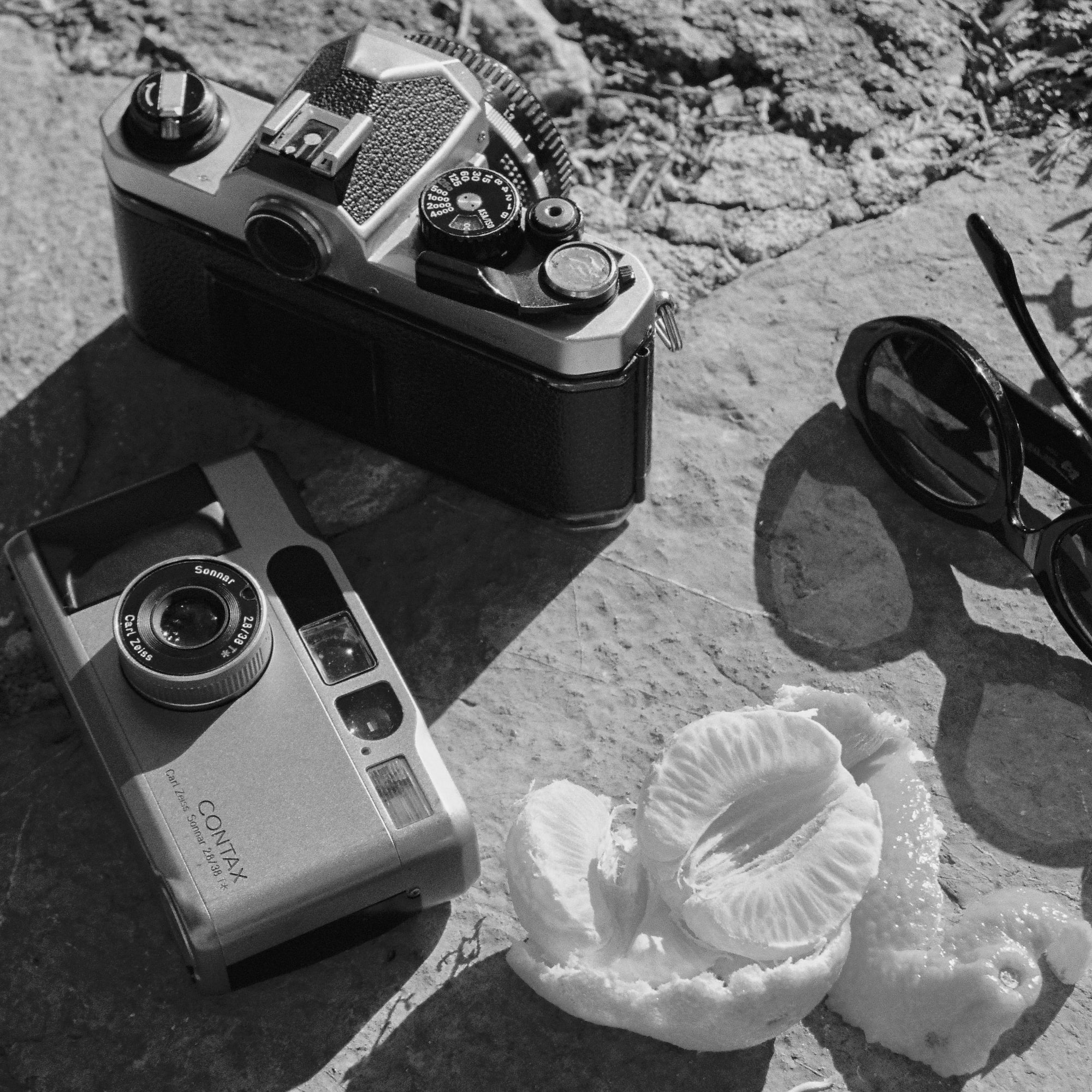 a camera and sunglasses on a rock
