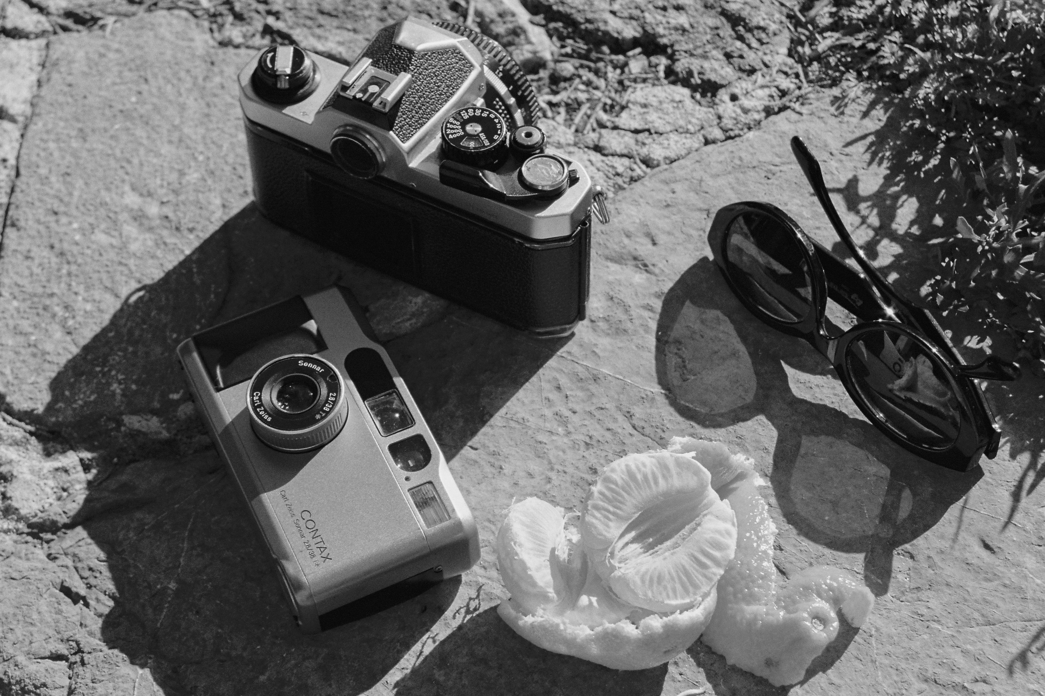 a camera and sunglasses on a rock