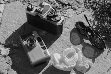 a camera and sunglasses on a rock