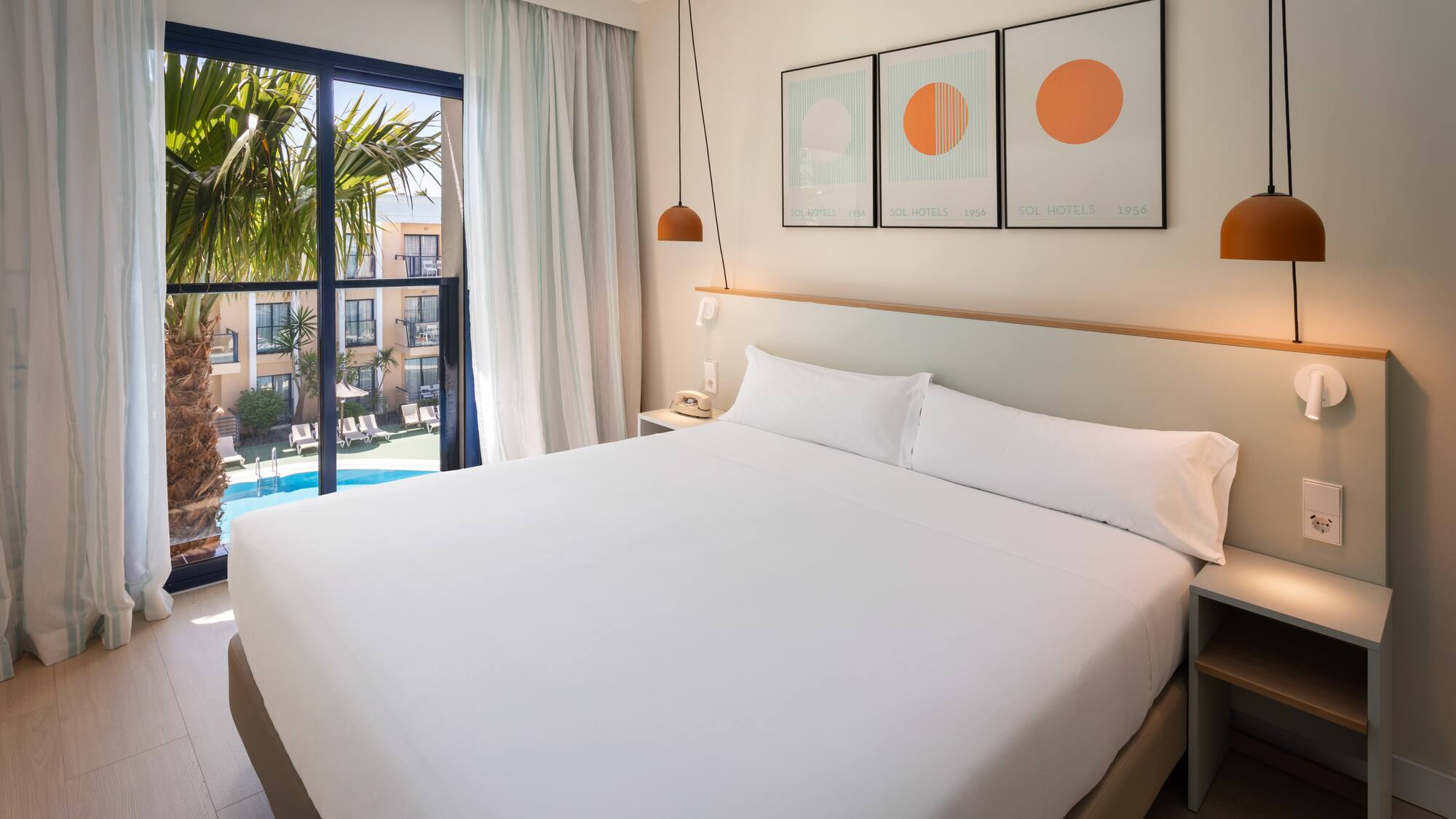 a bed with white sheets and pillows in a hotel room