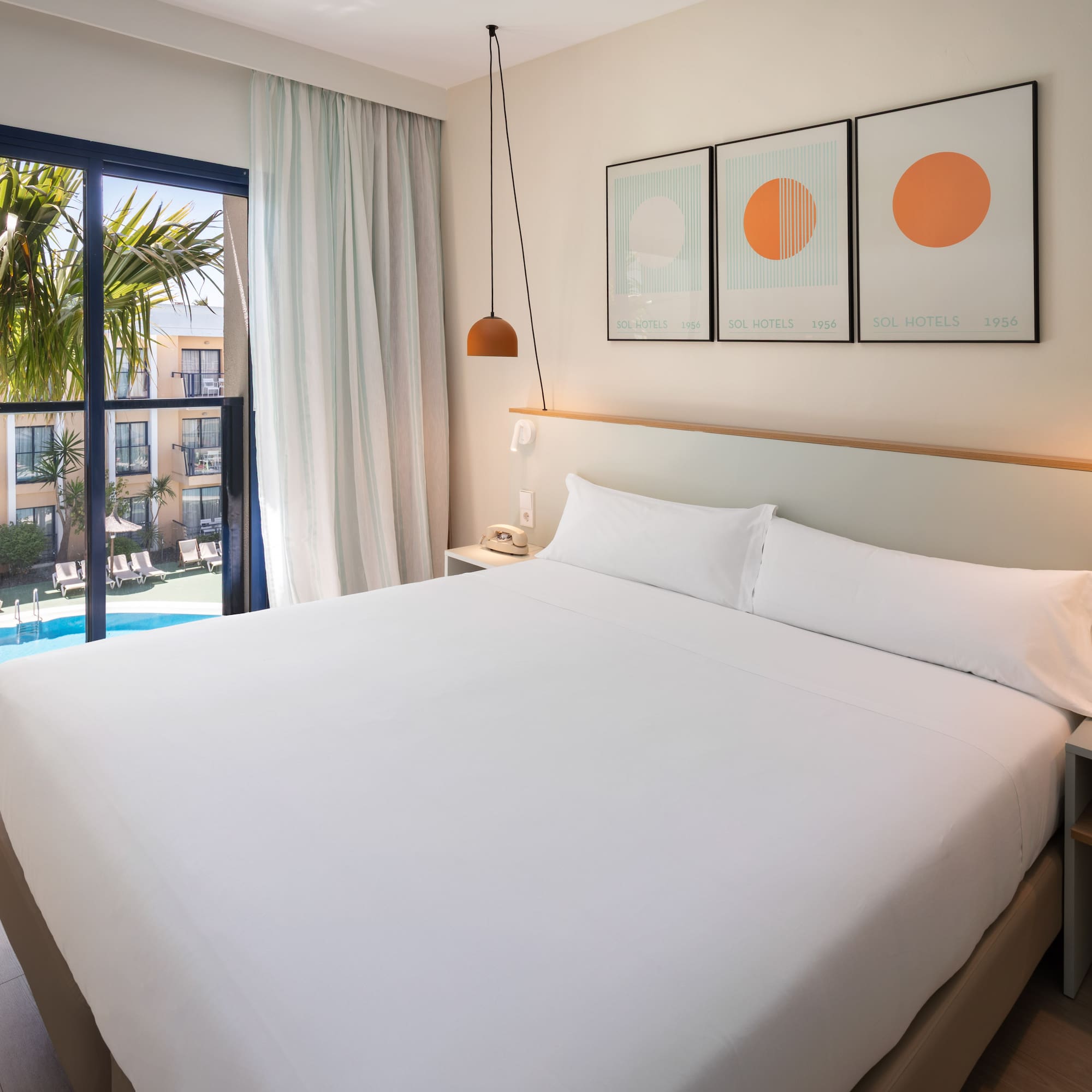 a bed with white sheets and pillows in a hotel room