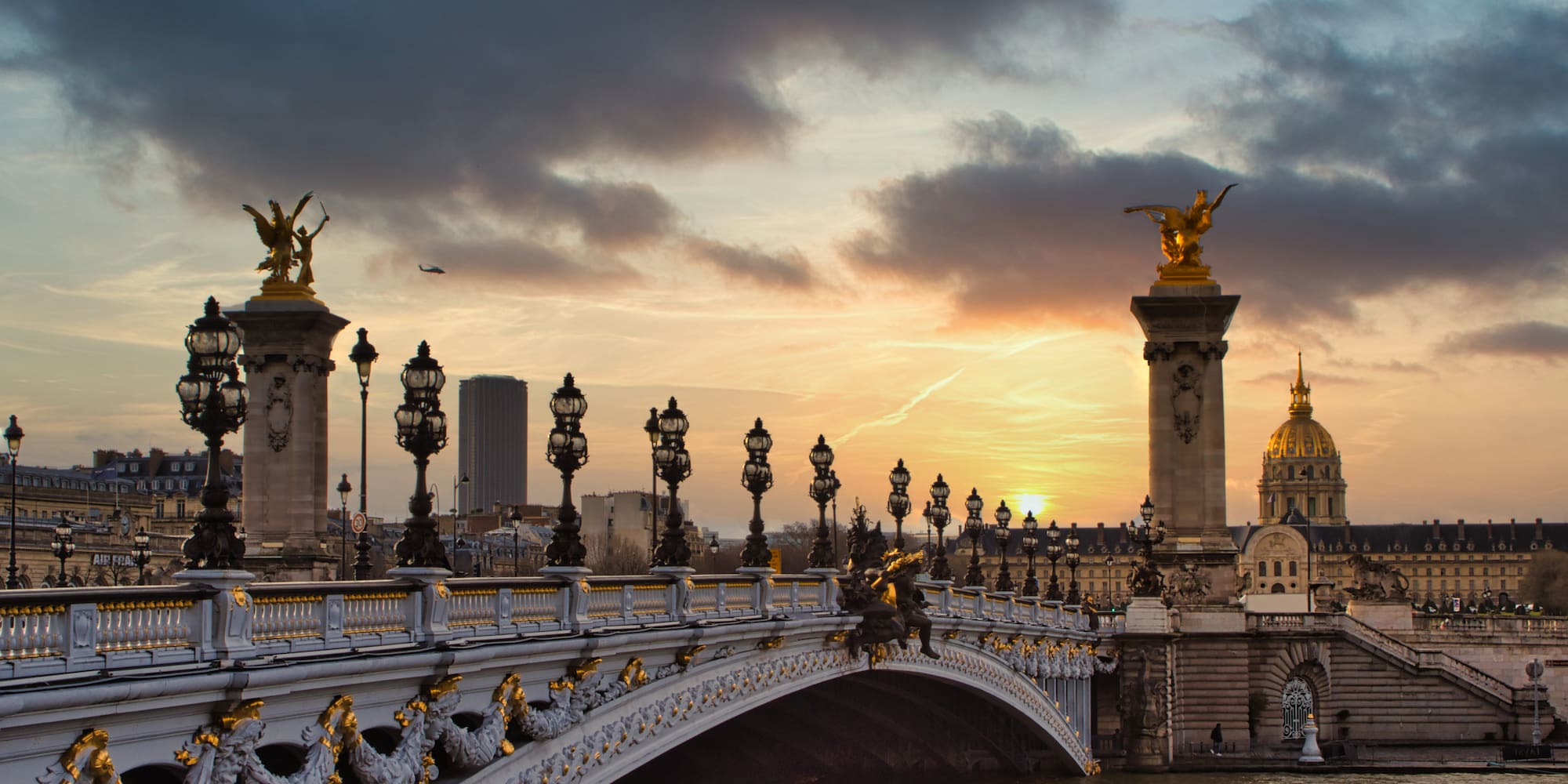 a bridge with a body of water and statues