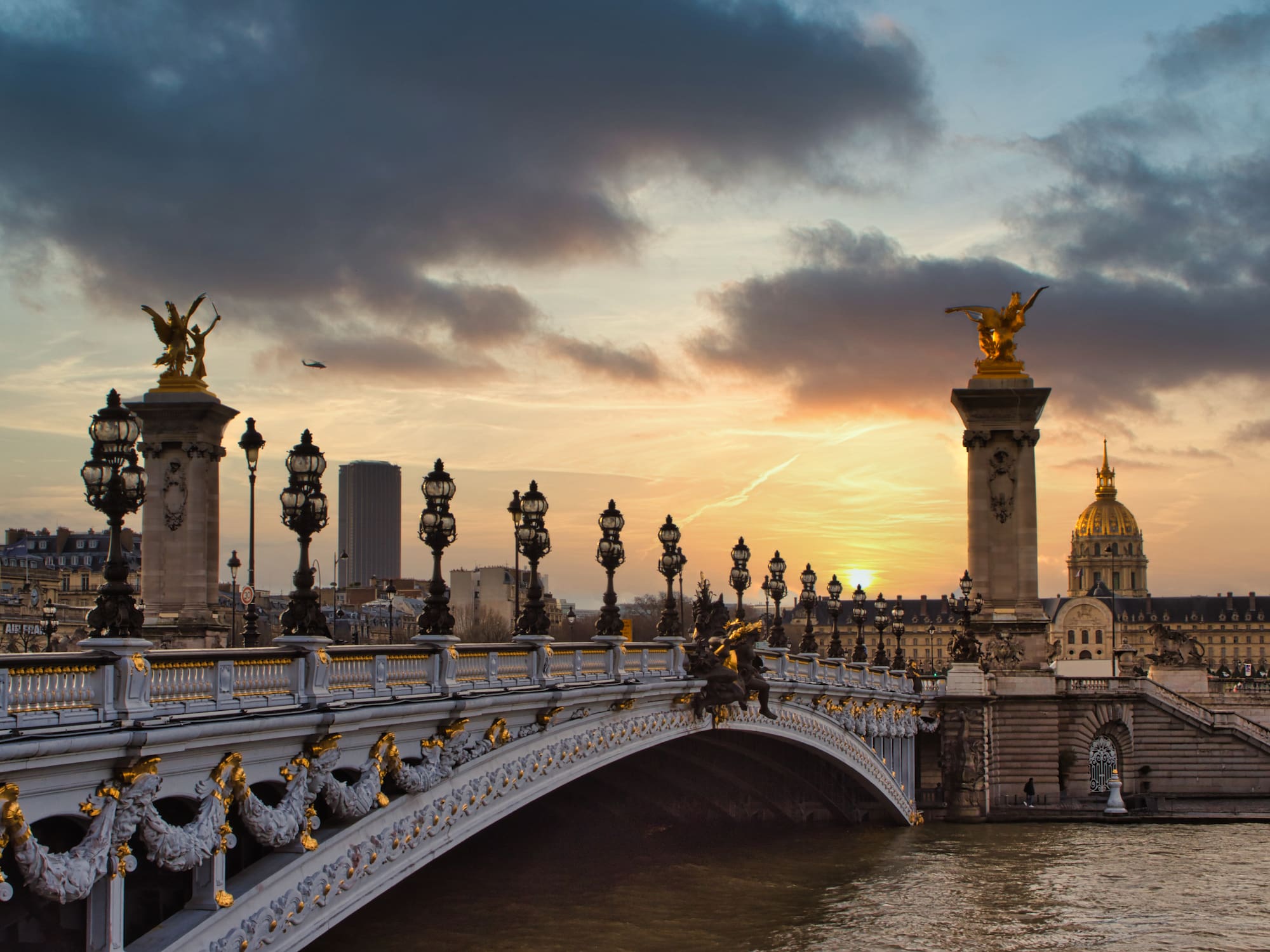 a bridge with a body of water and statues