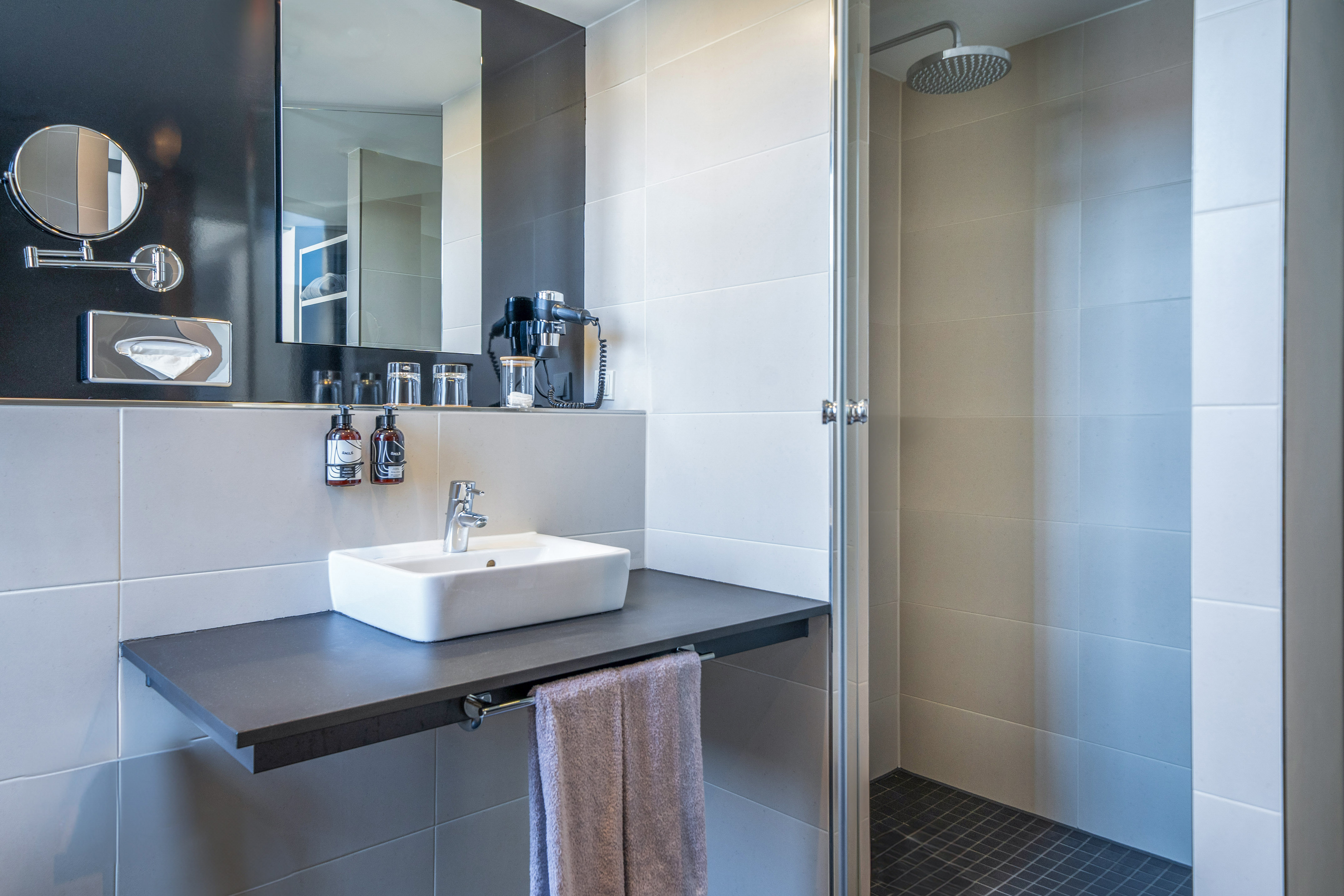 Modern bathroom with white sink, large mirror, and tiled walk-in shower. - The INNSiDE Premium Room - Innside Berlin Mitte, Berlijn