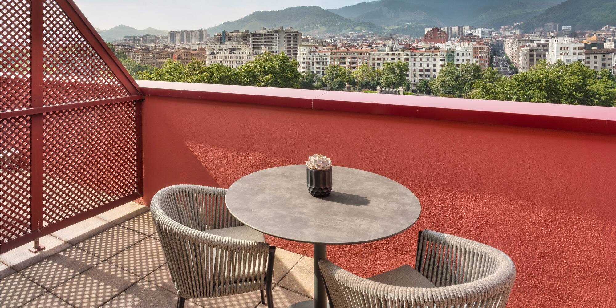 a table and chairs on a balcony overlooking a city
