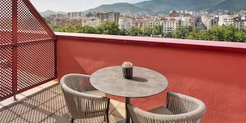 a table and chairs on a balcony overlooking a city