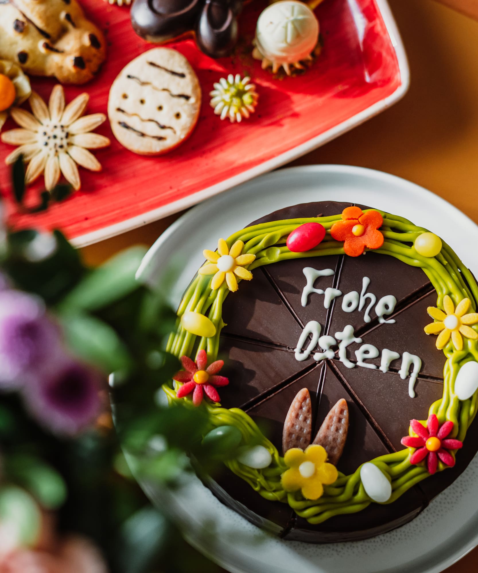 a chocolate cake with flowers and cookies