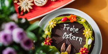 a chocolate cake with flowers and cookies