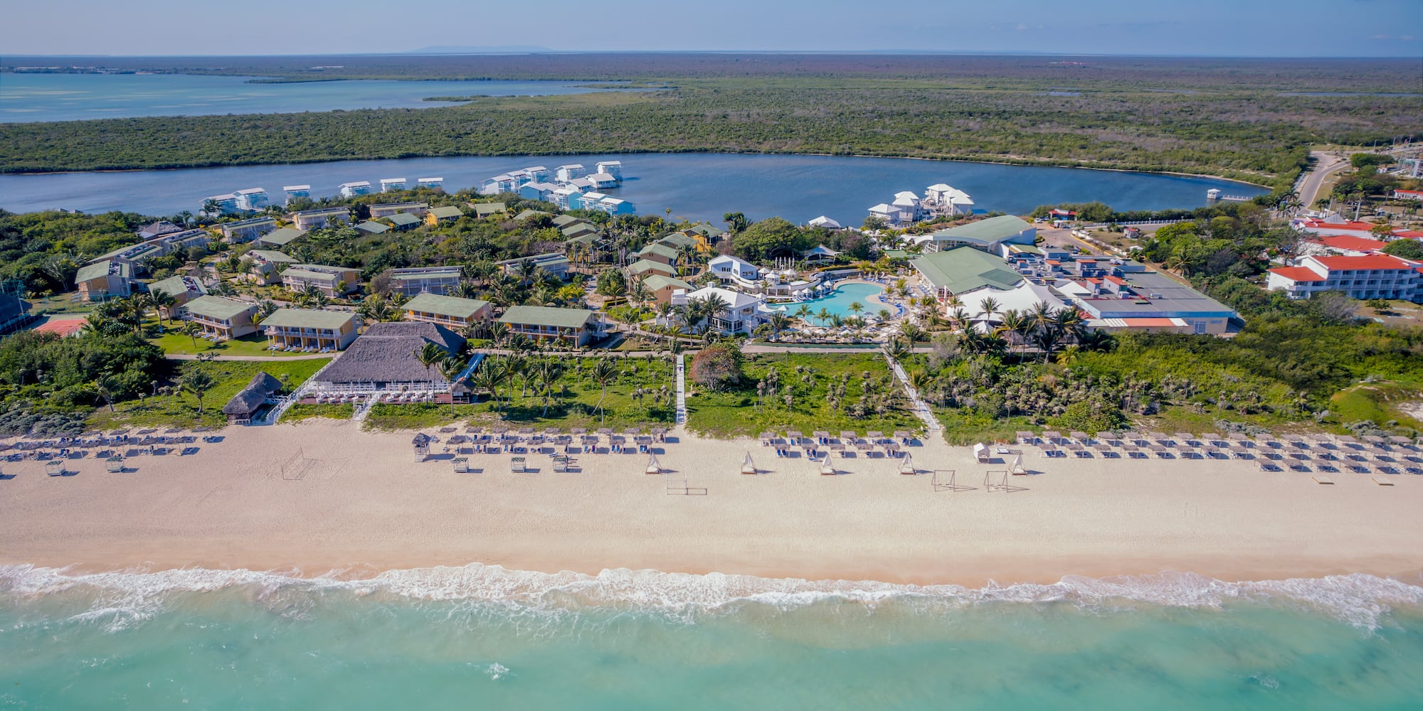 a beach with a group of buildings and a pool on it