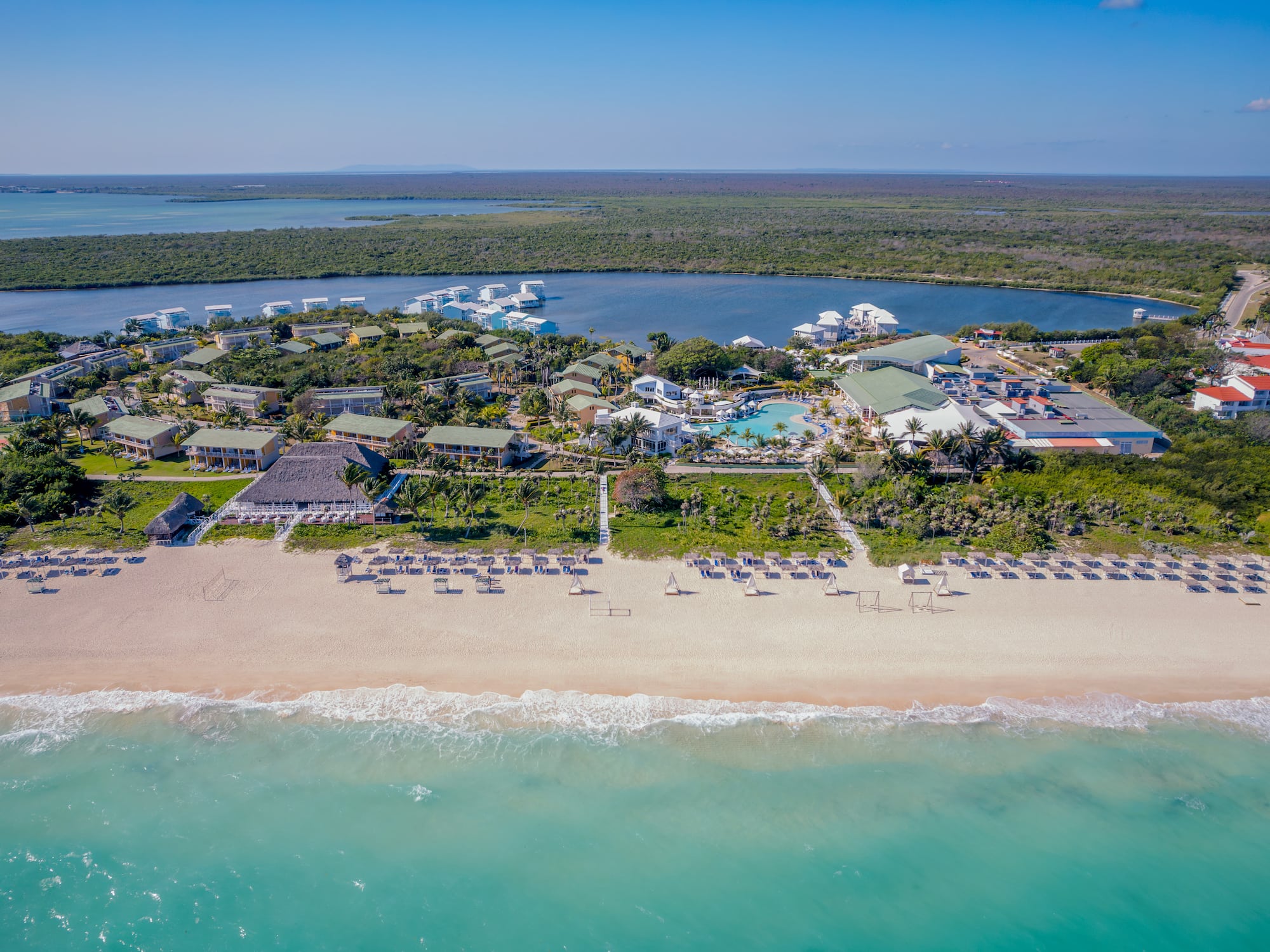 a beach with a group of buildings and a pool on it