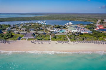 a beach with a group of buildings and a pool on it