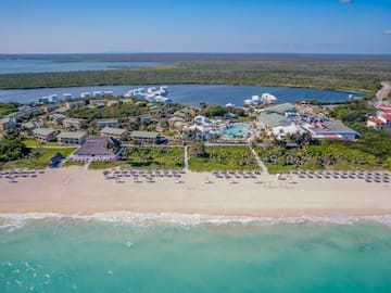 a beach with a group of buildings and a pool on it