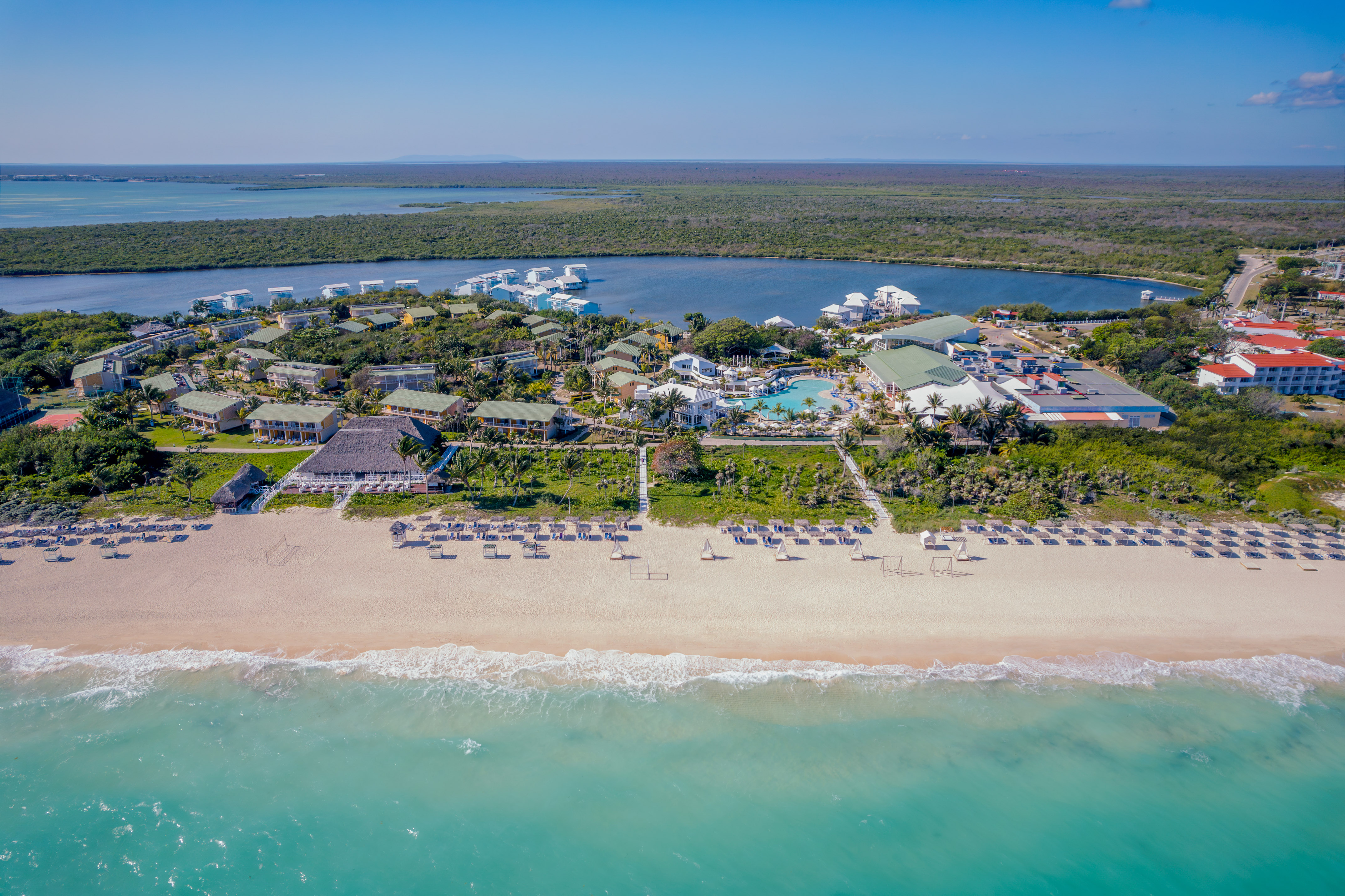 a beach with a group of buildings and a pool on it