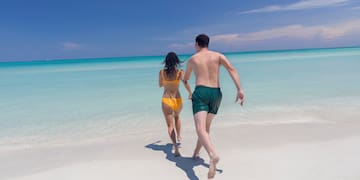 a man and woman running on a beach