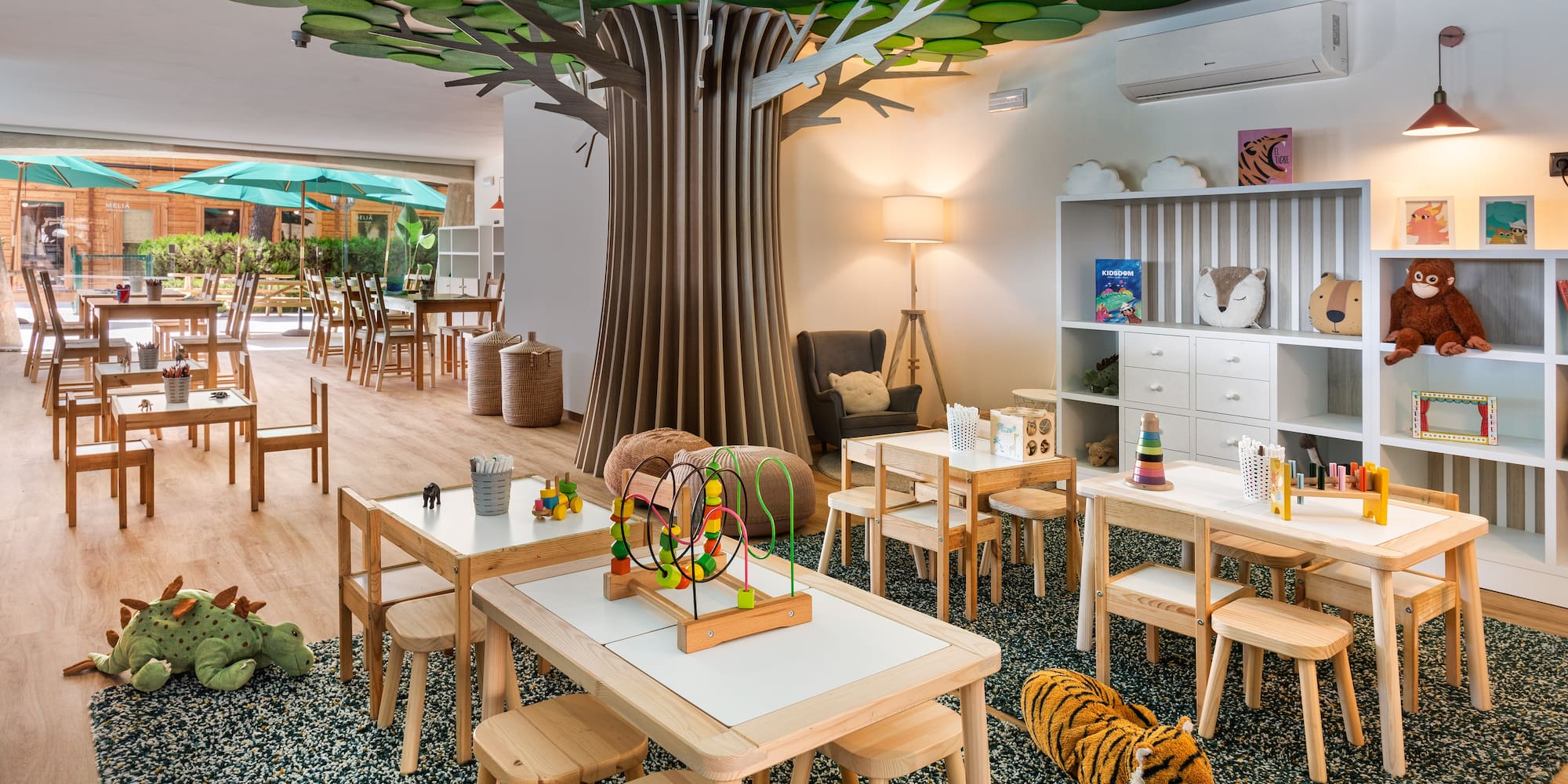 a room with tables and chairs and a tree