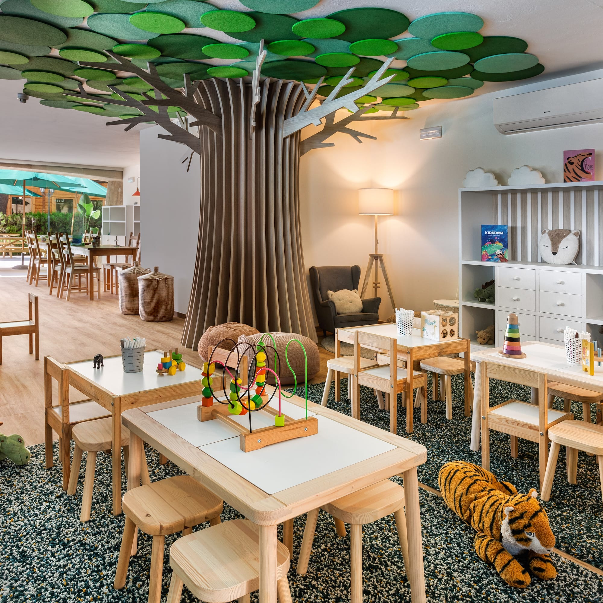 a room with tables and chairs and a tree