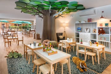 a room with tables and chairs and a tree