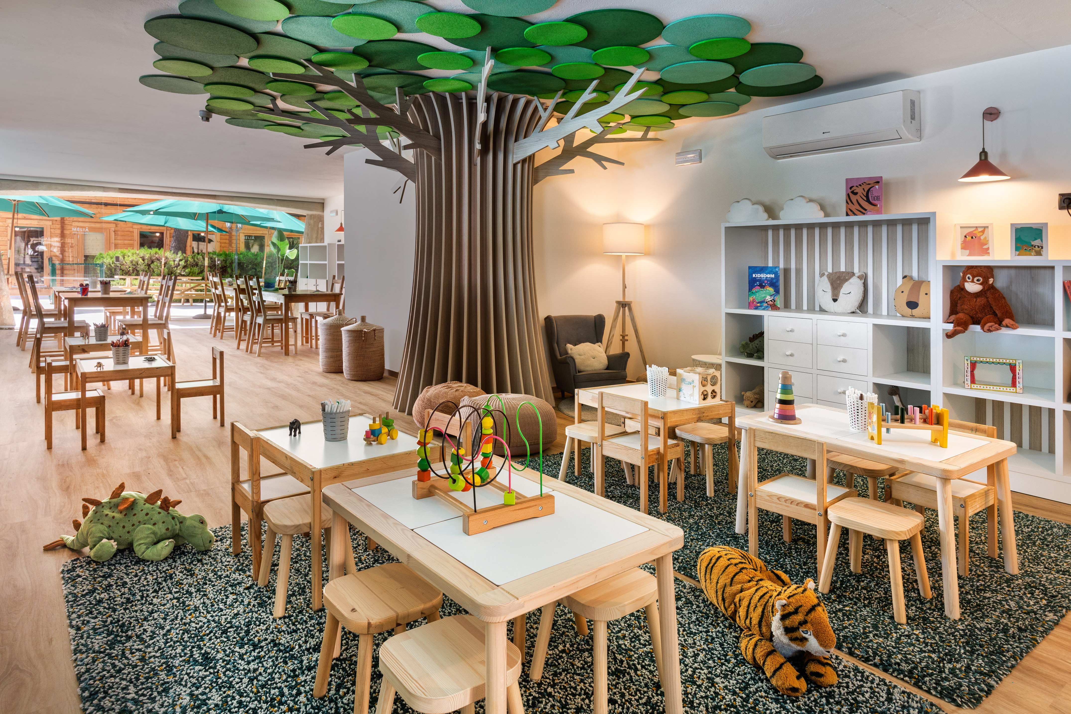 a room with tables and chairs and a tree