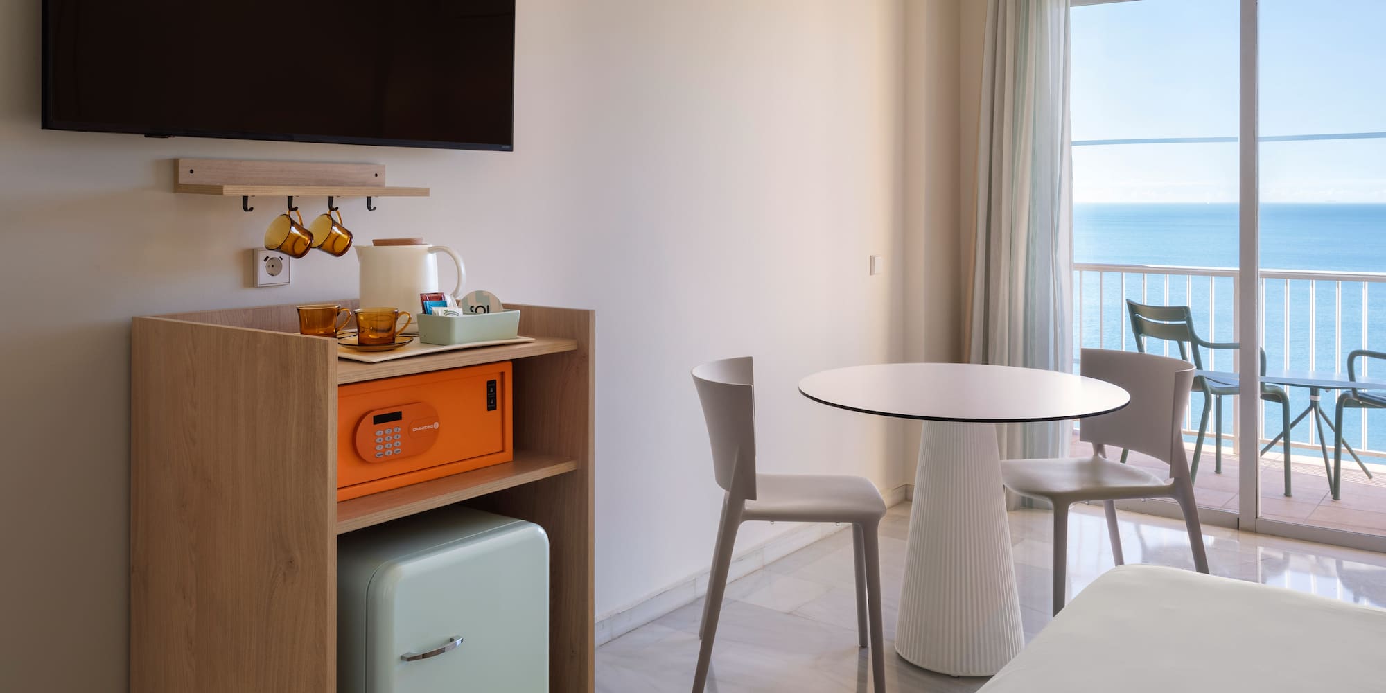 a room with a table and chairs and a television