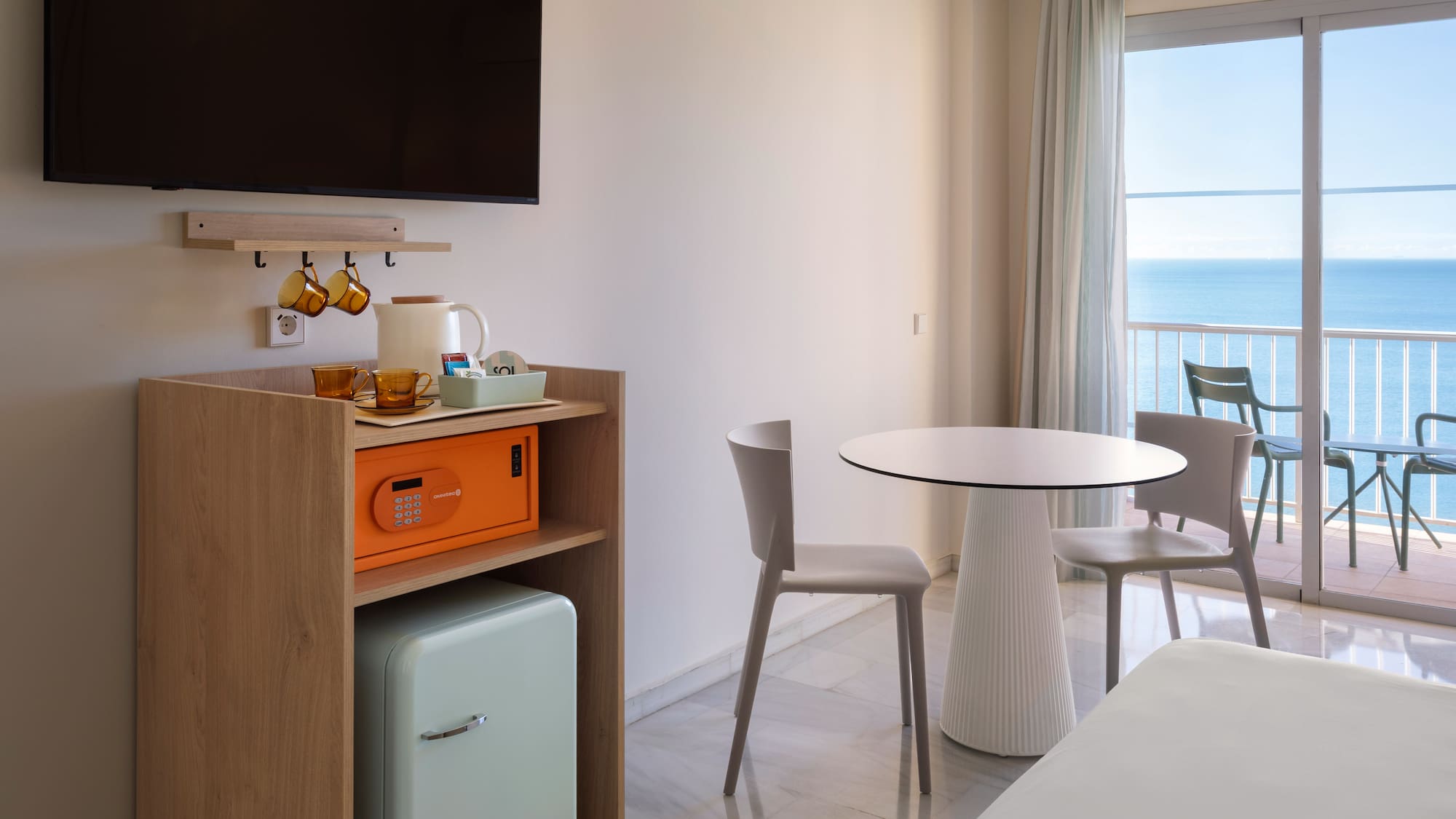 a room with a table and chairs and a television