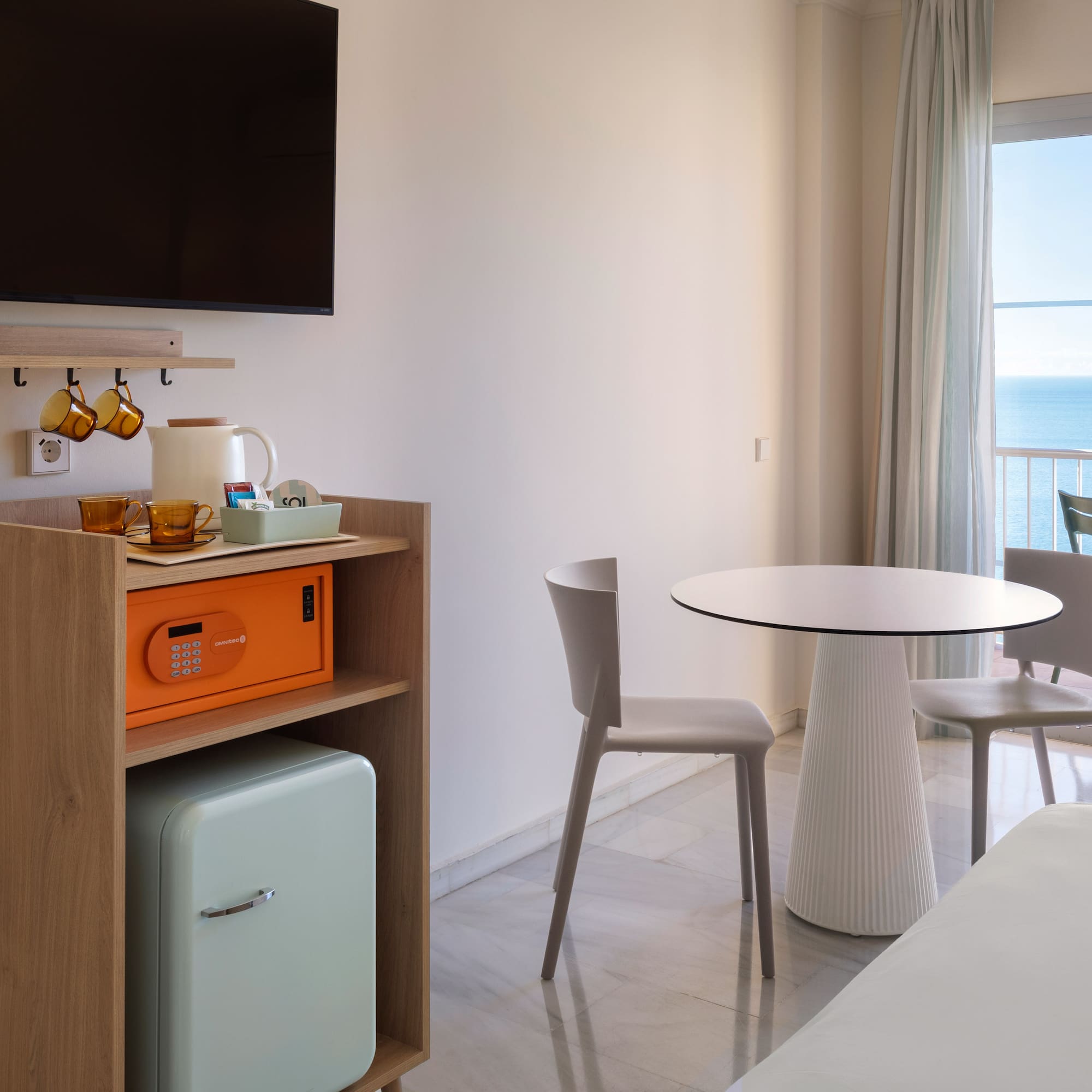 a room with a table and chairs and a television