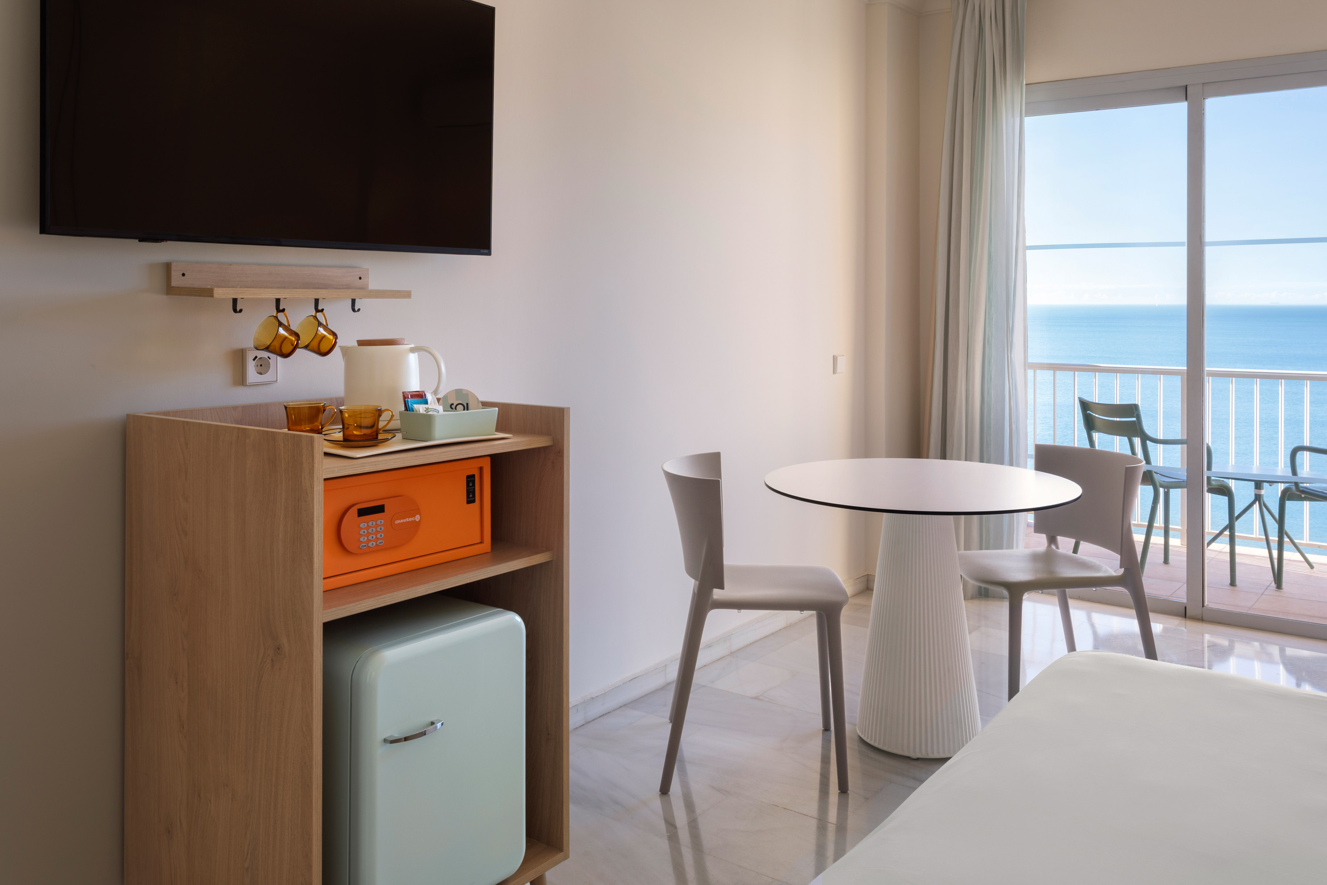 a room with a table and chairs and a television