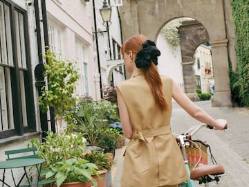 a woman with a bicycle on a street