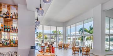 a room with tables and chairs and a table with a few windows