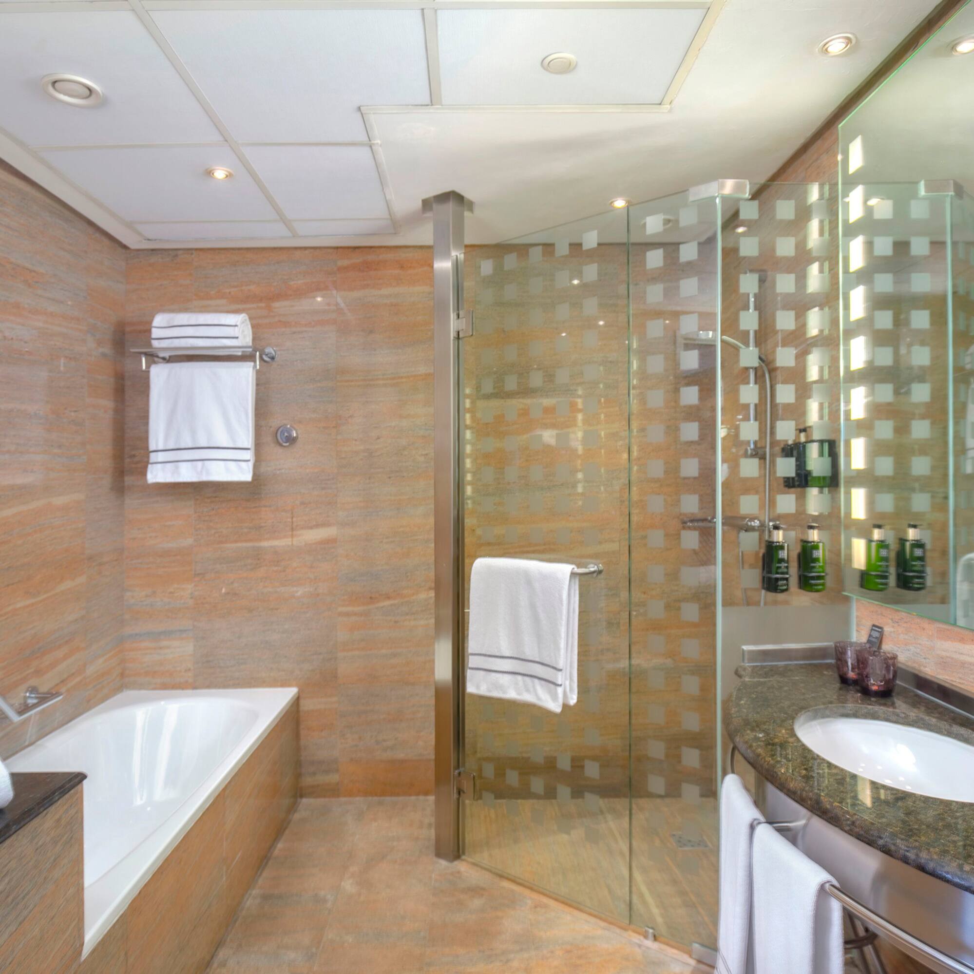 a bathroom with a glass shower and tub