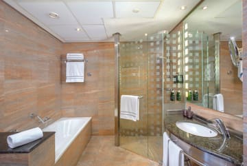 a bathroom with a glass shower and tub