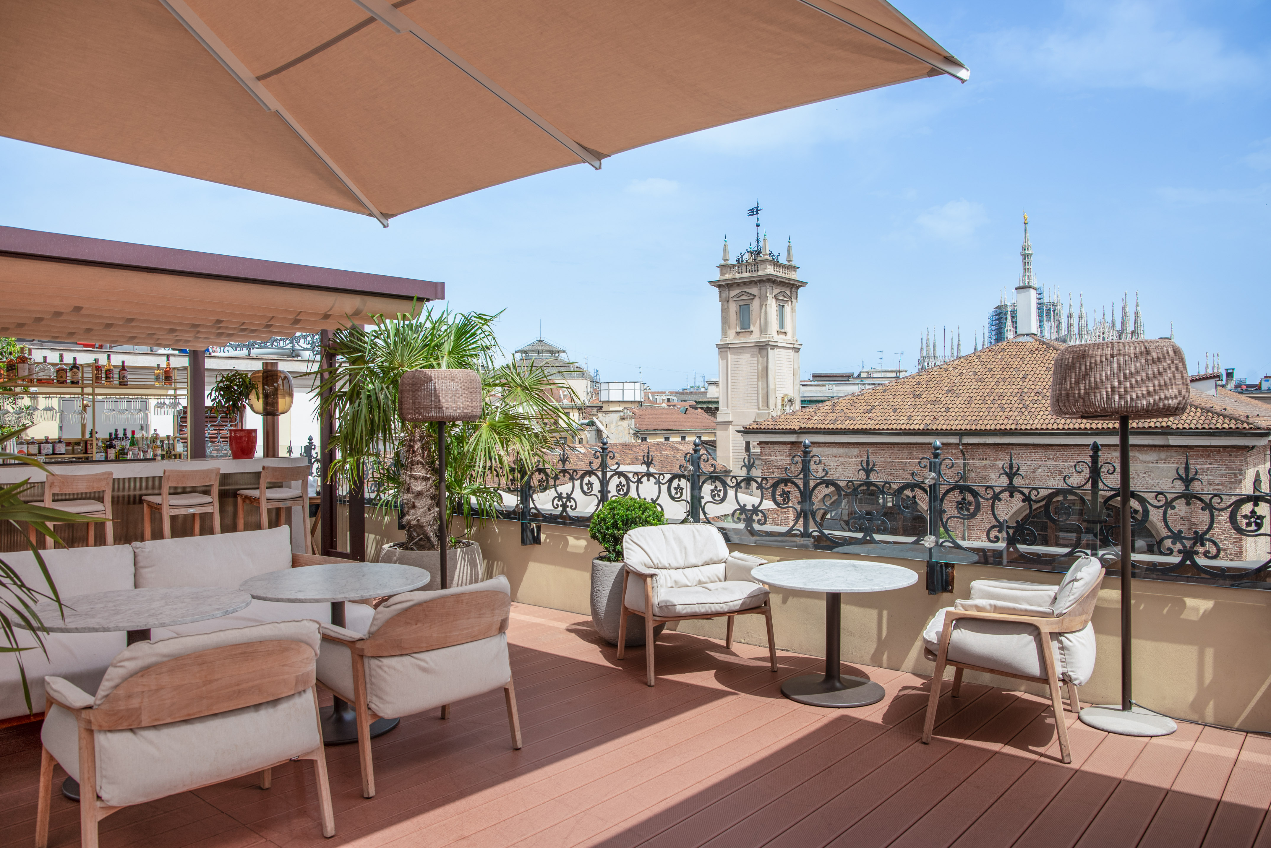 a patio with chairs and tables on a rooftop