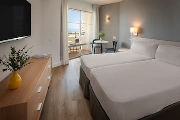 a room with two beds and a television