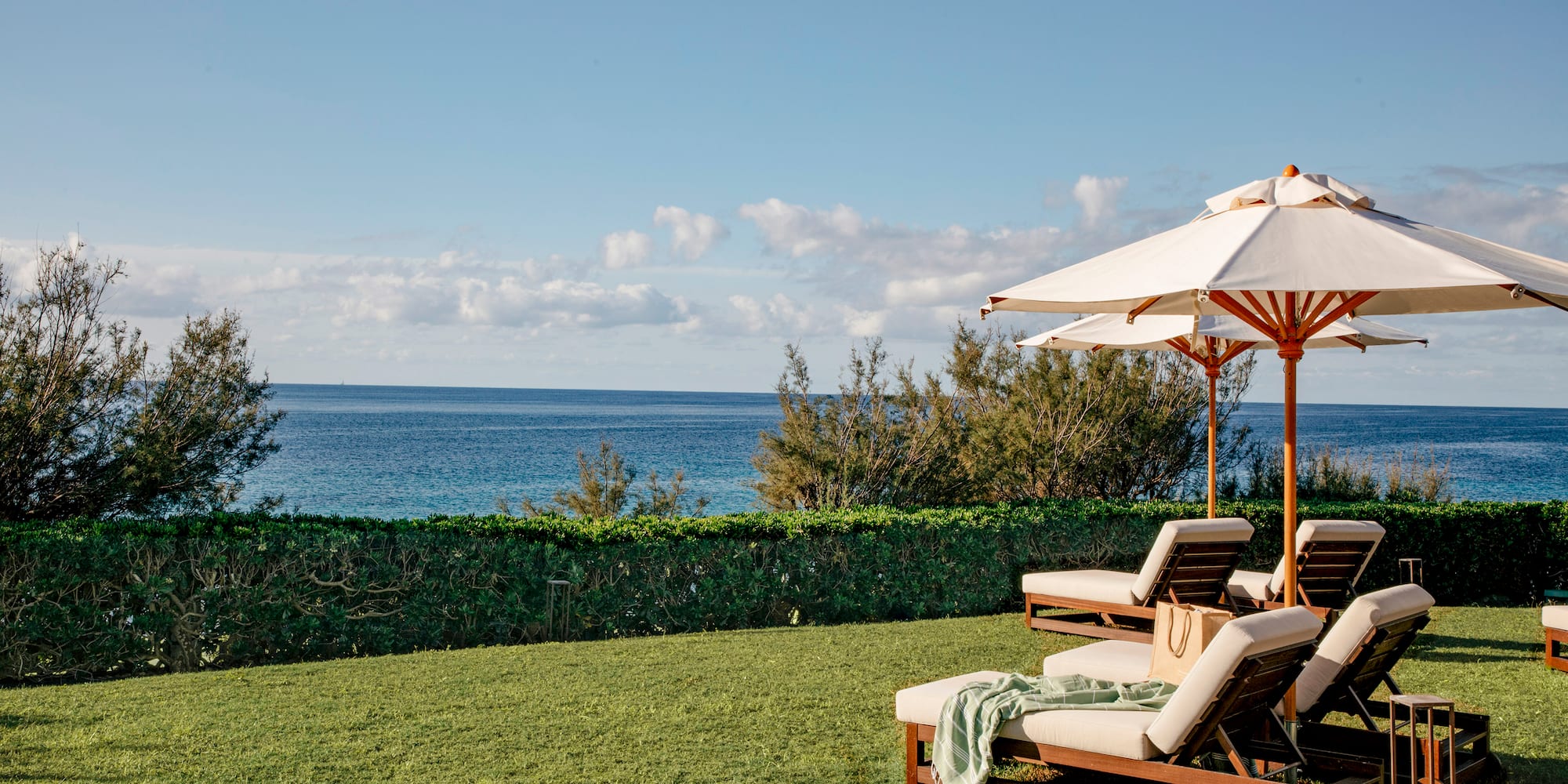 a lawn chairs and umbrellas with a body of water in the background