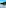 Golf course lake with green fairways, palm trees, and bright sun.