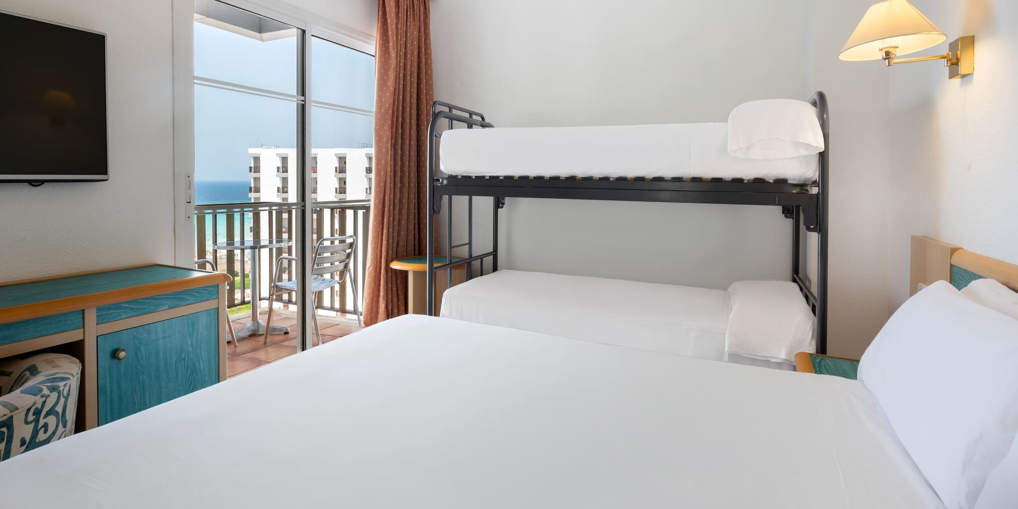 a bunk beds in a room with a balcony overlooking the ocean