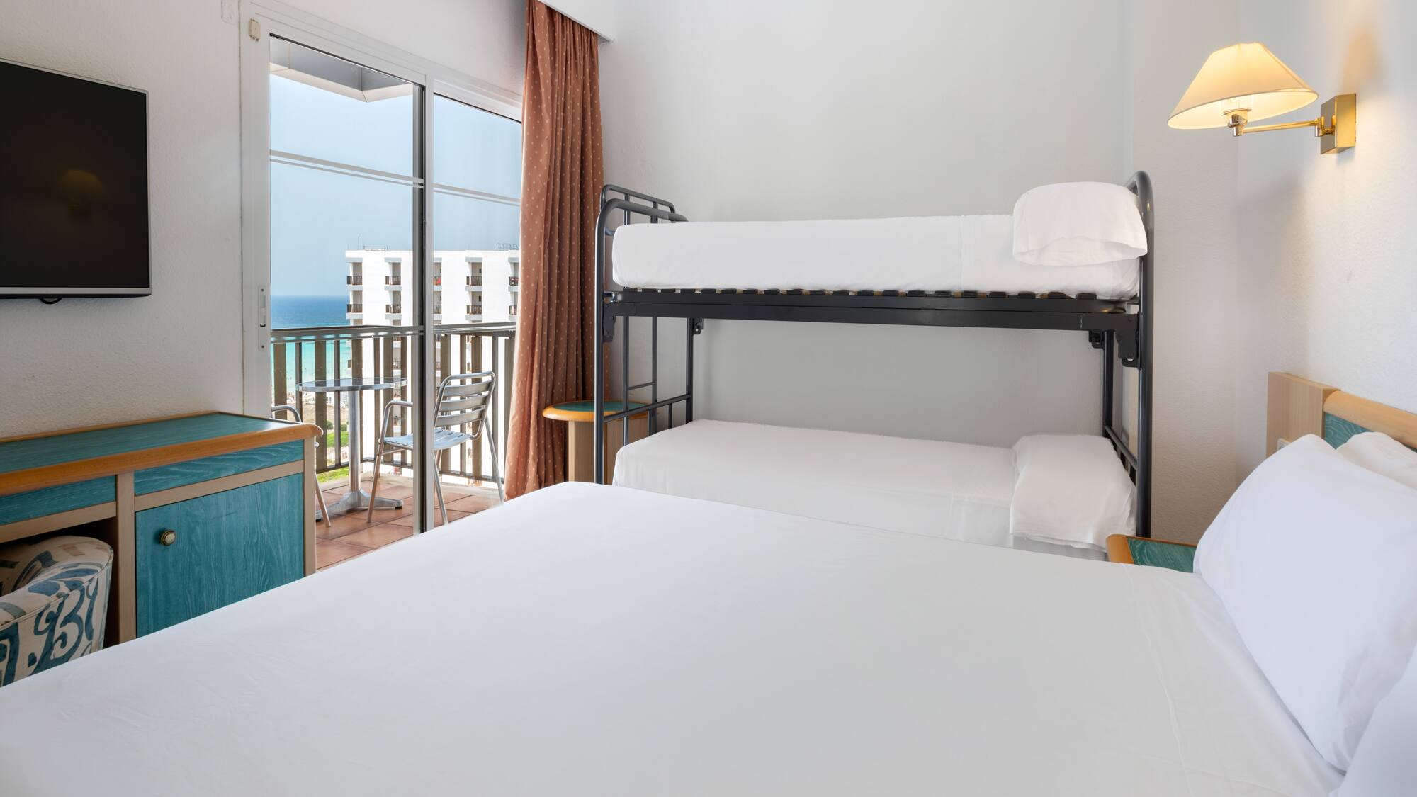 a bunk beds in a room with a balcony overlooking the ocean