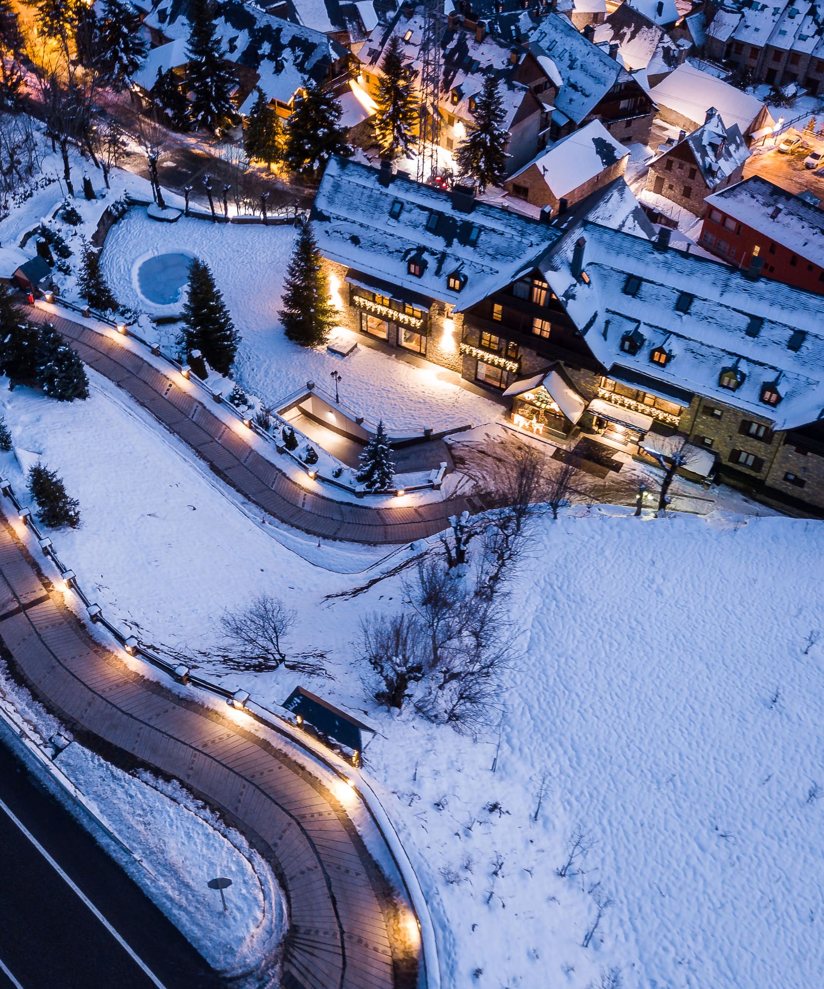 a road and buildings with lights and snow