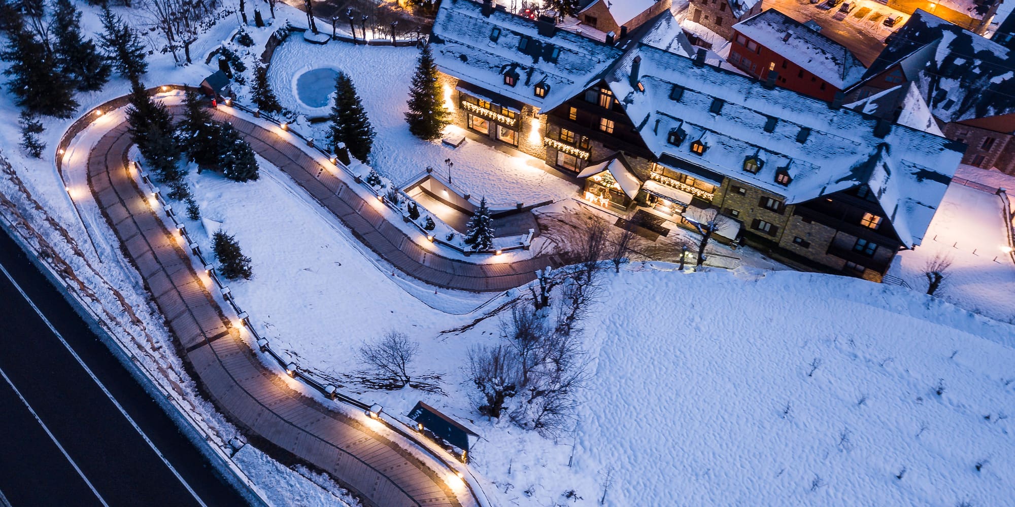 a road and buildings with lights and snow