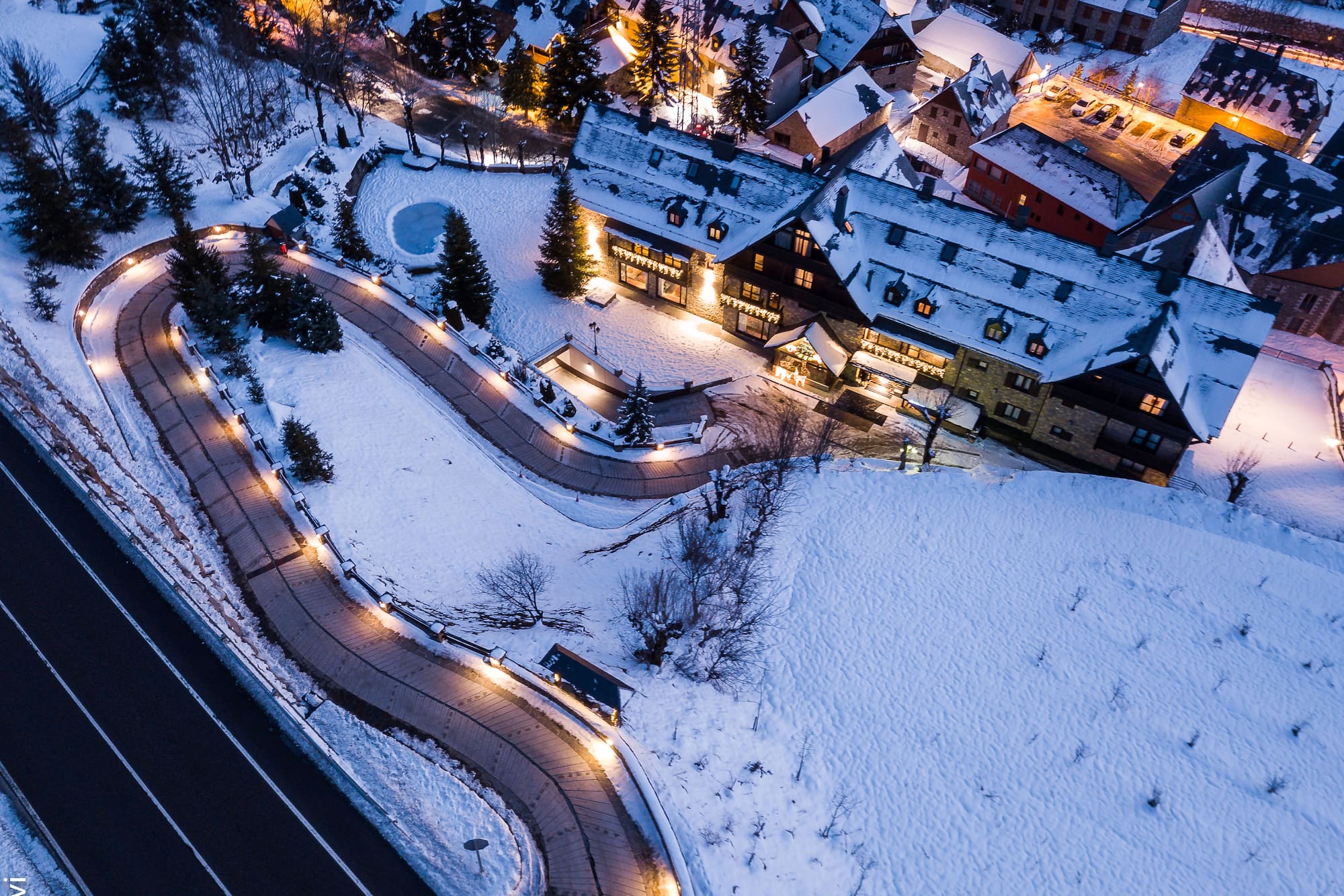 a road and buildings with lights and snow
