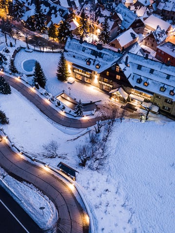 a road and buildings with lights and snow