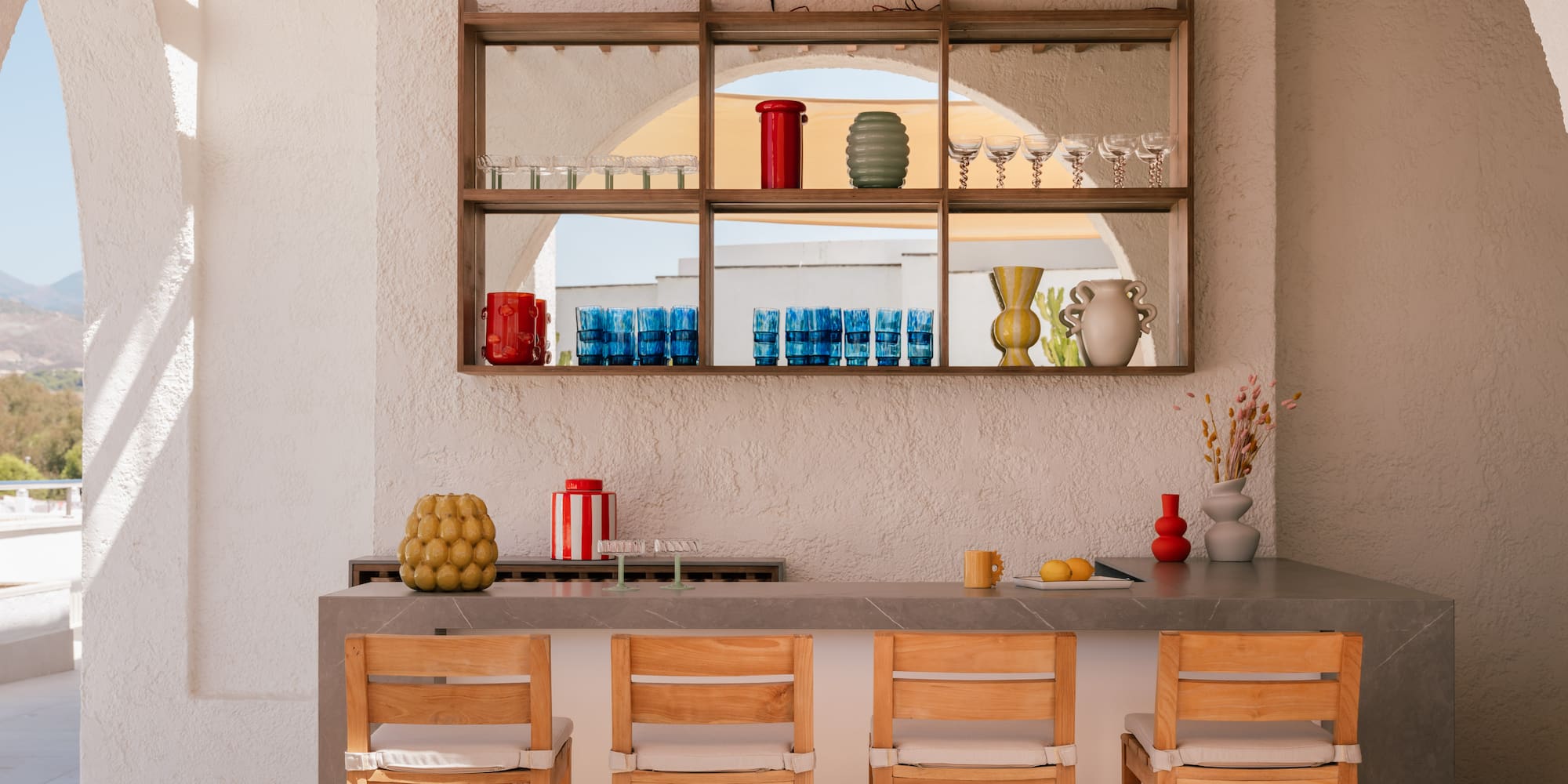 a bar with chairs and a shelf above it