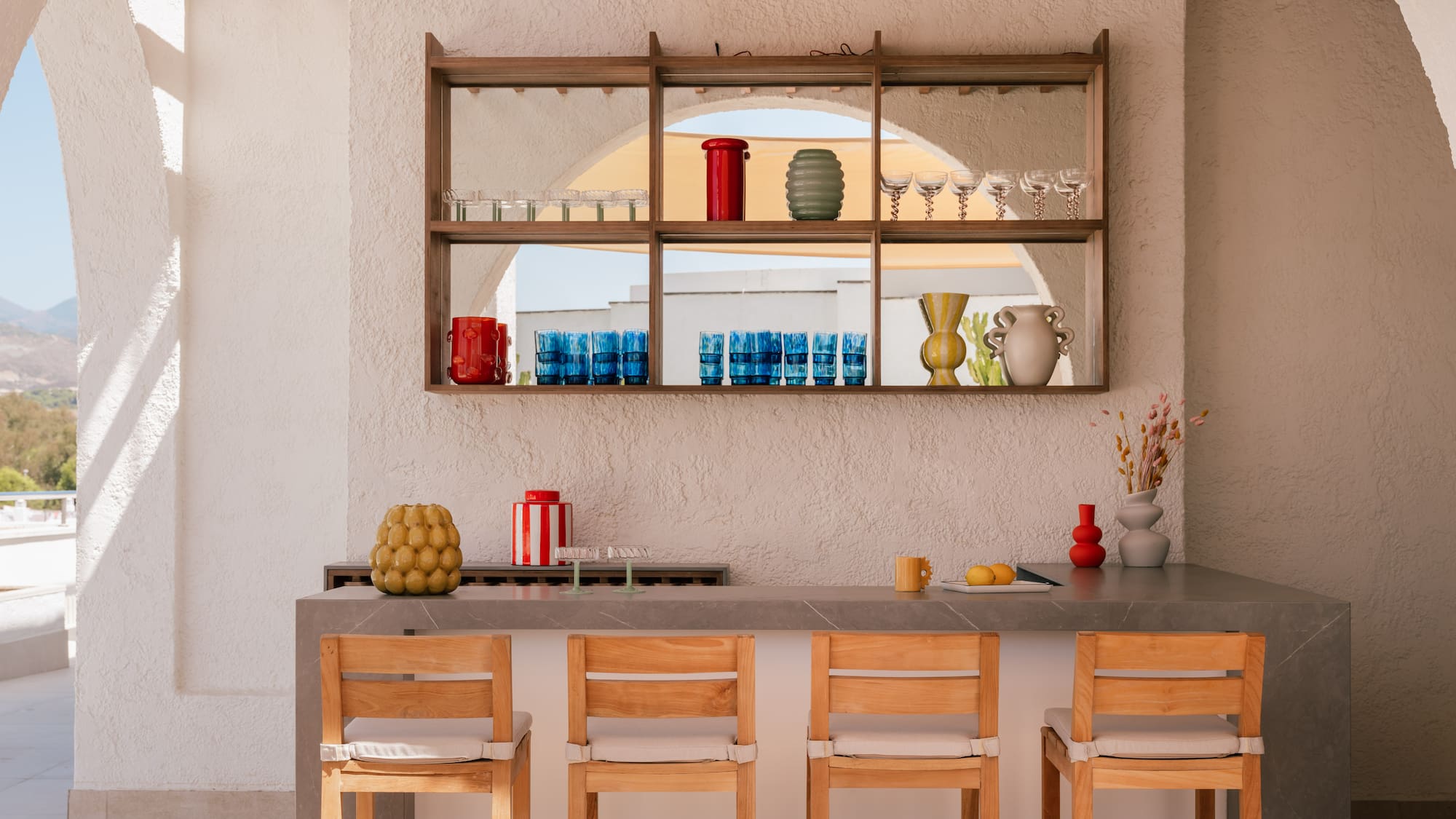a bar with chairs and a shelf above it