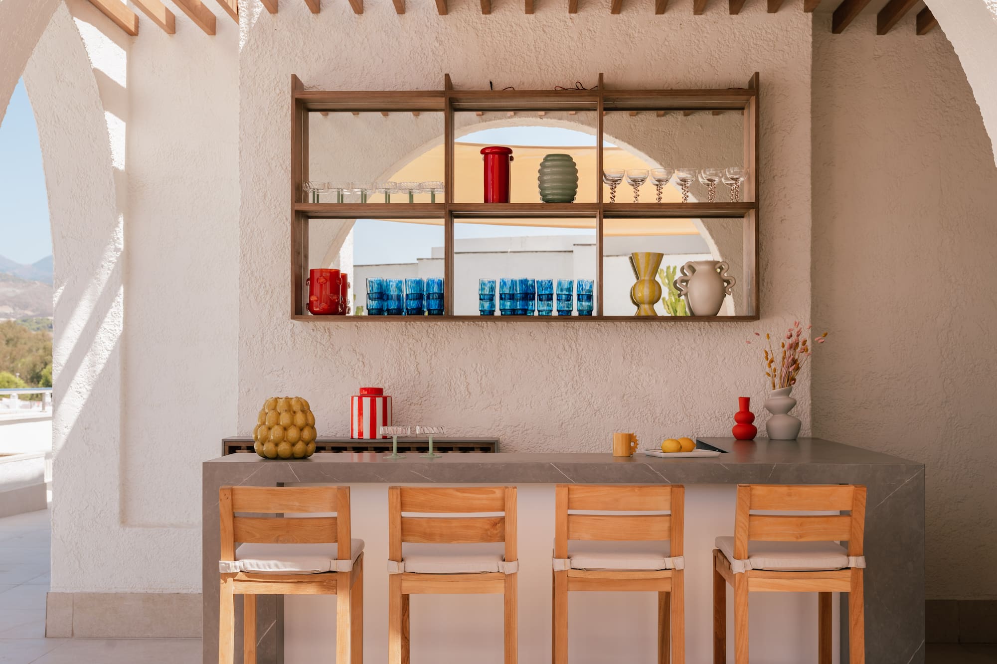a bar with chairs and a shelf above it