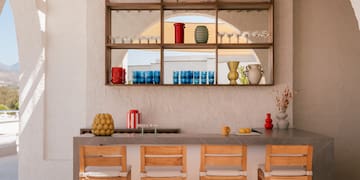 a bar with chairs and a shelf above it