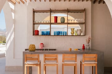 a bar with chairs and a shelf above it