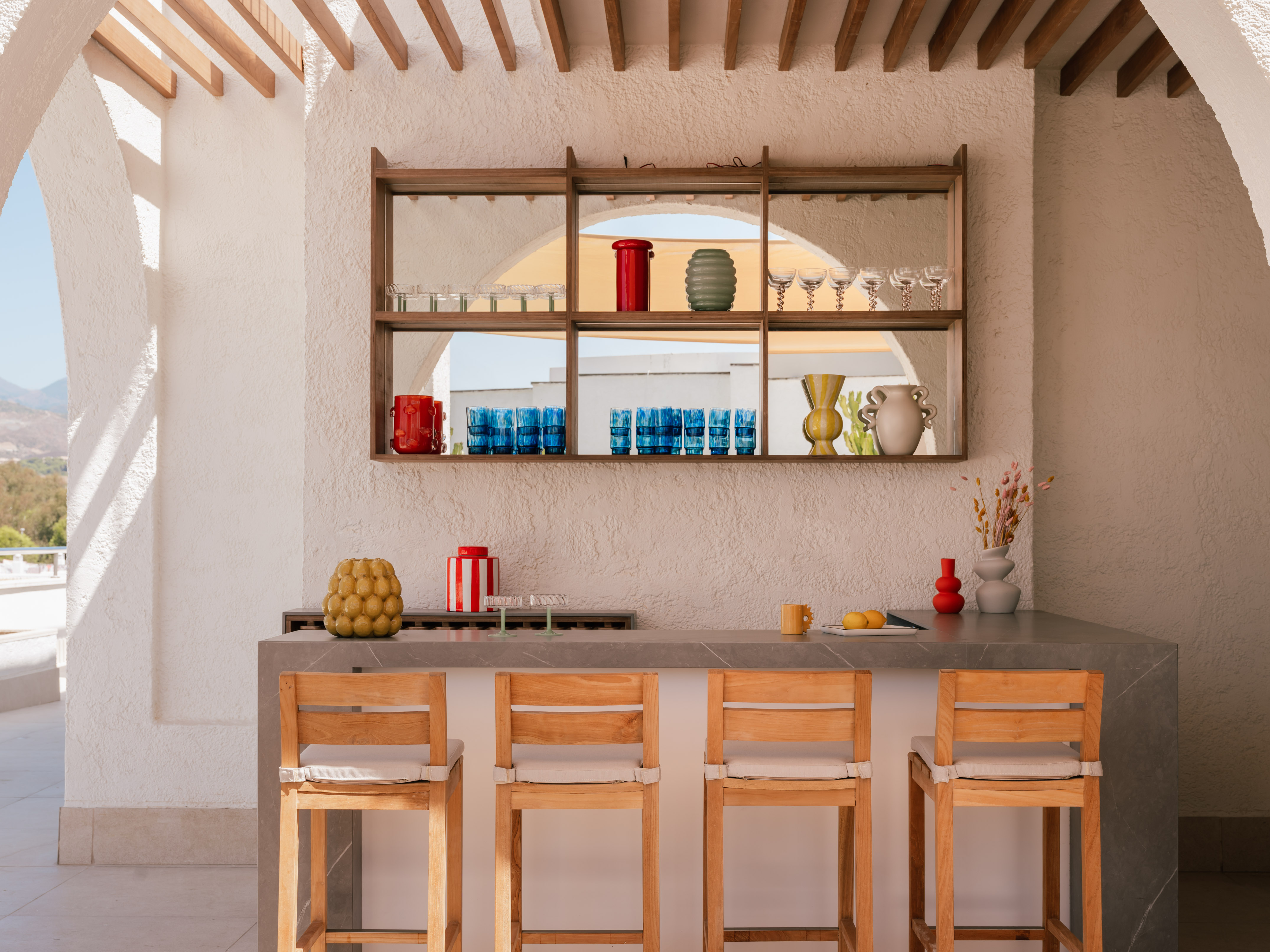a bar with chairs and a shelf above it