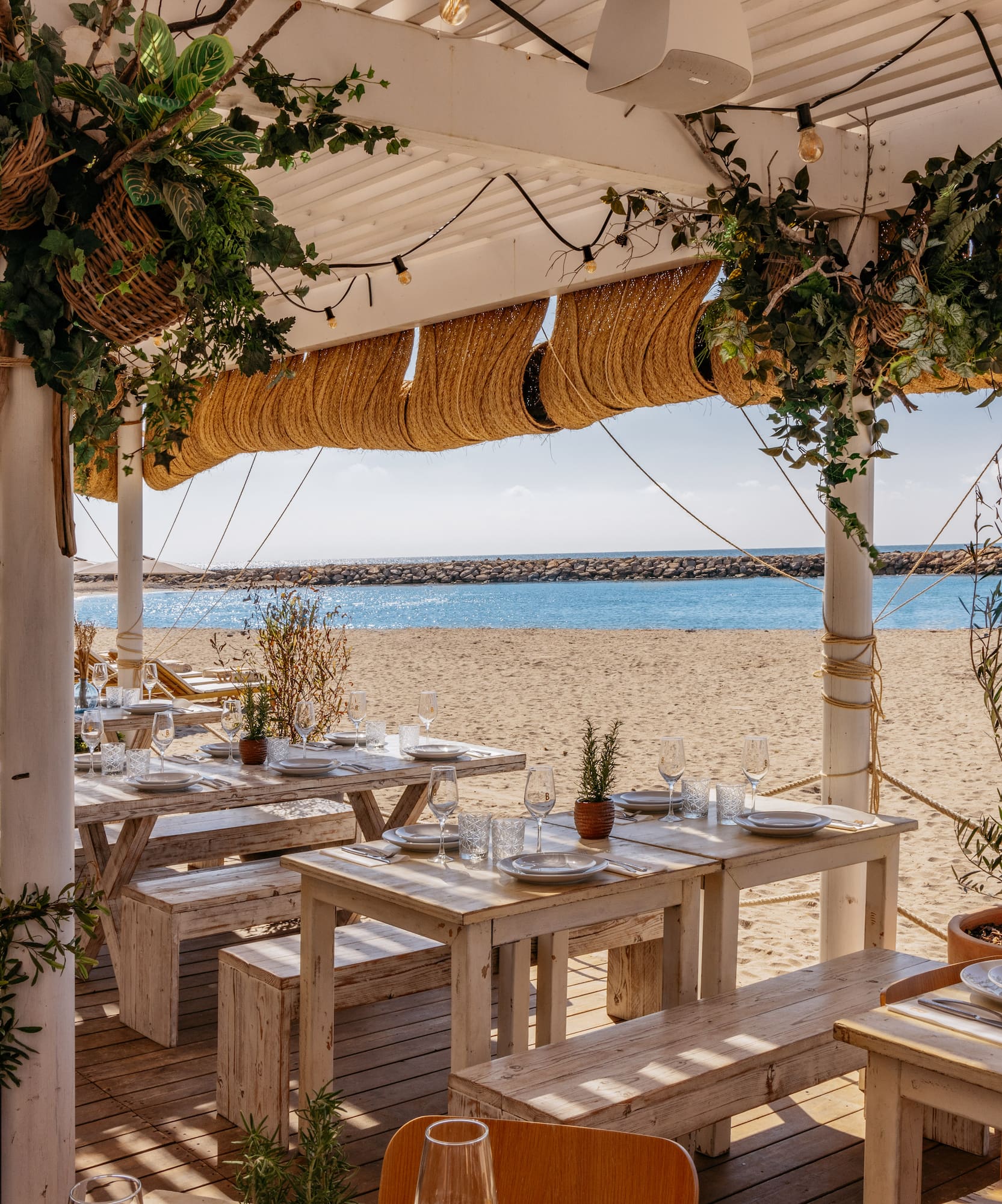 a beach restaurant with tables and chairs