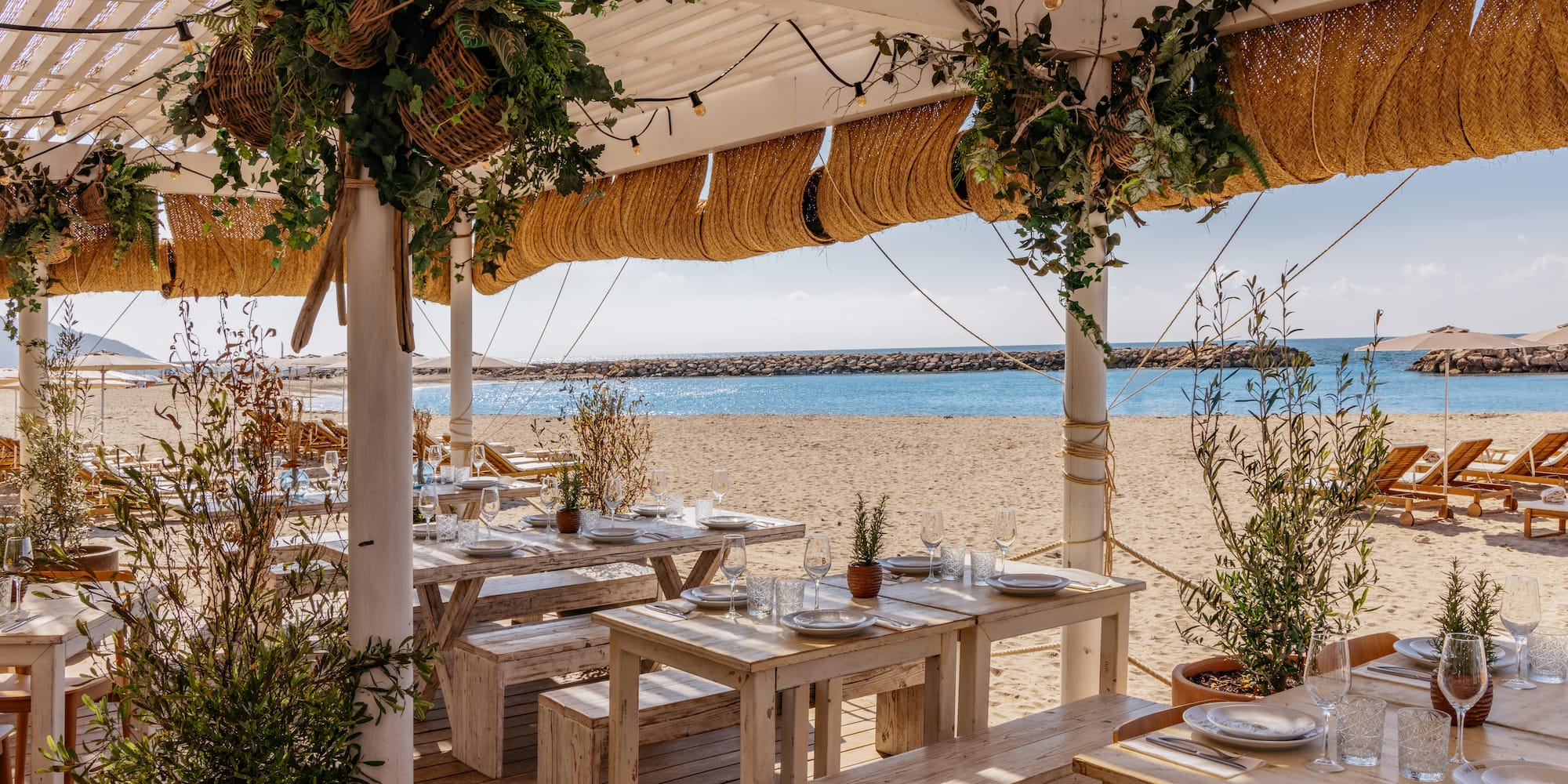 a beach restaurant with tables and chairs